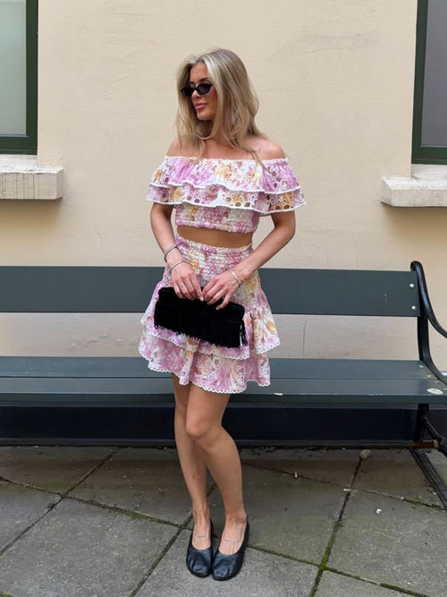 Pink floral broderie anglaise off-shoulder top with layered ruffles and smocked bodice