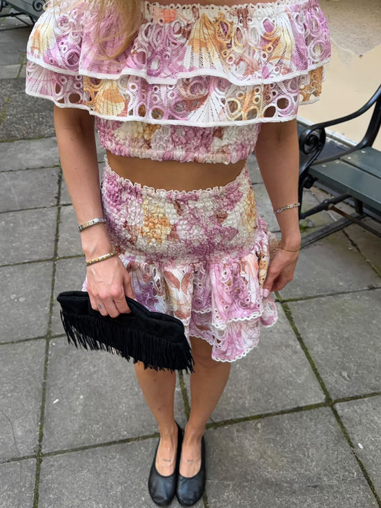 Pink floral broderie anglaise off-shoulder top with layered ruffles and smocked bodice