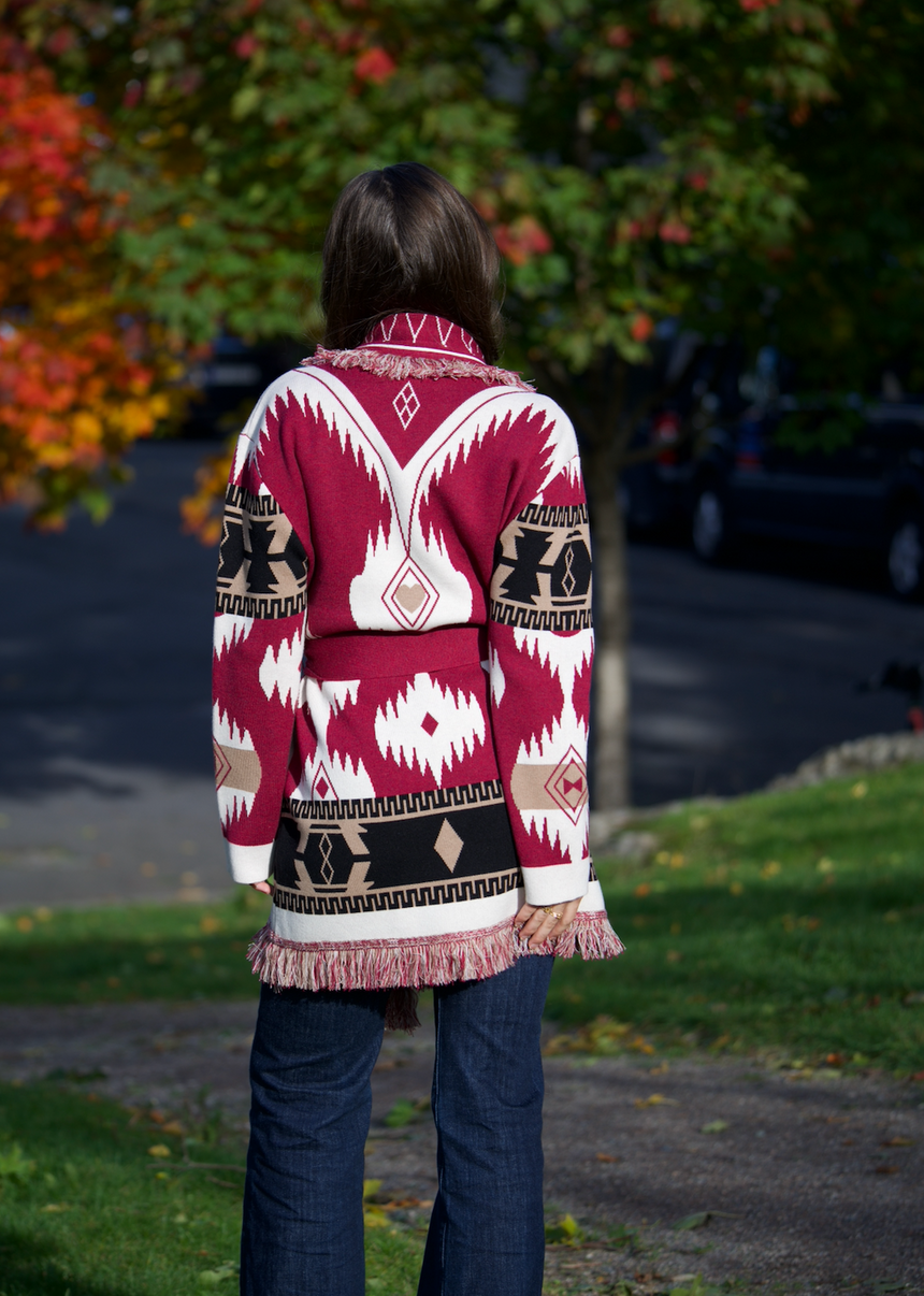 Burgundy merino wool wrap cardigan with bold Nordic knit pattern and fringed shawl collar