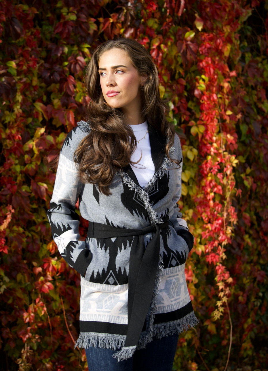 Grey merino wool wrap cardigan with bold Nordic knit pattern and fringed shawl collar