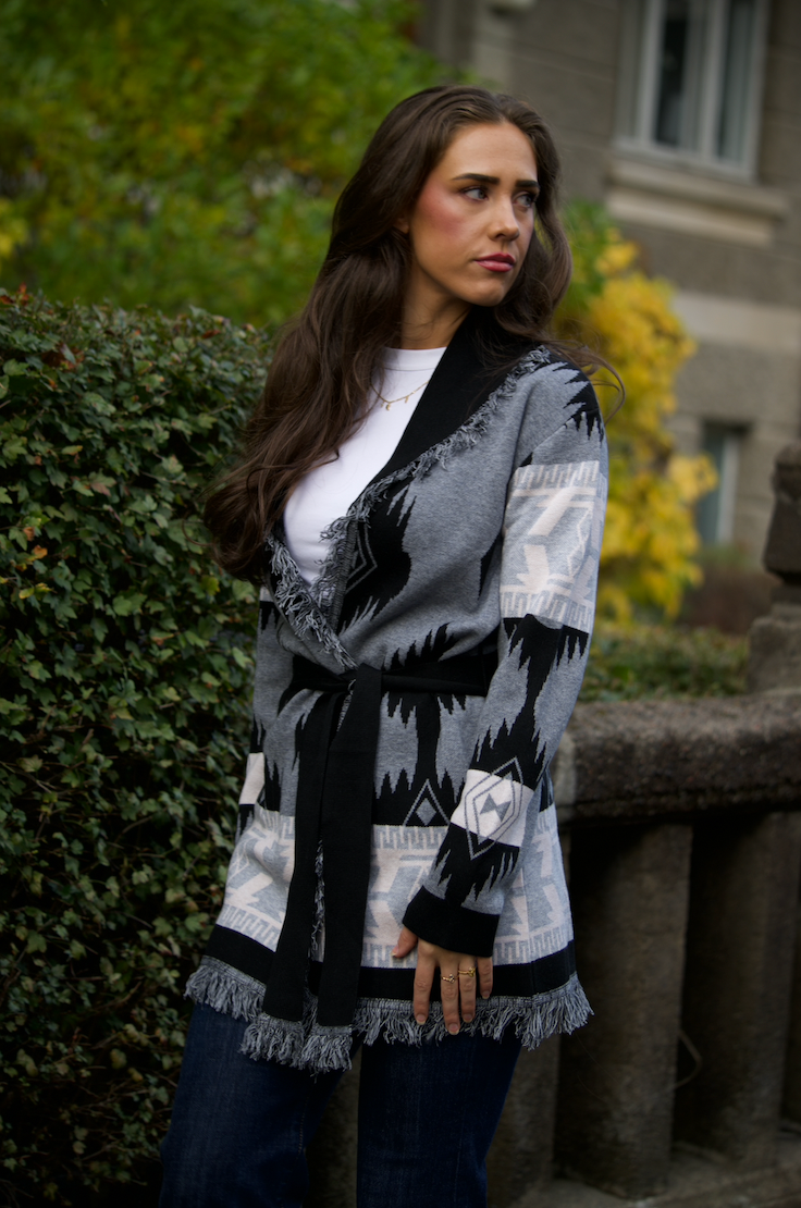 Grey merino wool wrap cardigan with bold Nordic knit pattern and fringed shawl collar