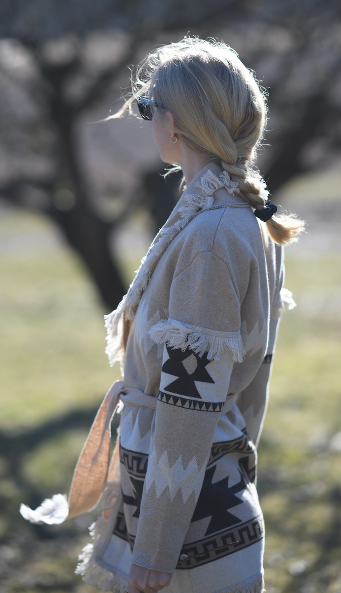 Sand merino wool wrap cardigan with bold geometric Nordic knit and fringed shawl collar